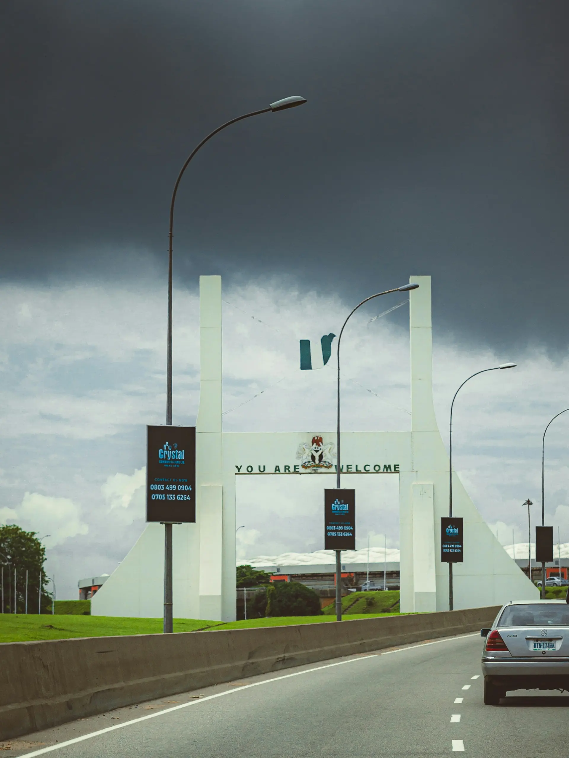 Abuja City Gate on the expressway under a stormy sky